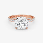 Rose gold ring with a large diamond and smaller diamonds on the band, on a white background.