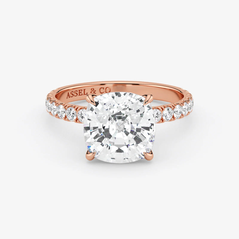 Rose gold ring with a large diamond and smaller diamonds on the band, on a white background.