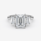 Diamond ring with emerald-cut stones on a white background
