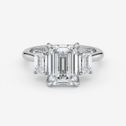 Diamond ring with emerald-cut stones on a white background