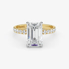 Gold ring with a large diamond and smaller diamonds on the band against a white background