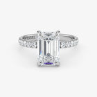 Diamond ring with emerald-cut center stone on a white background
