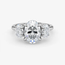 Diamond ring with a central oval-cut diamond and two smaller diamonds on a white background