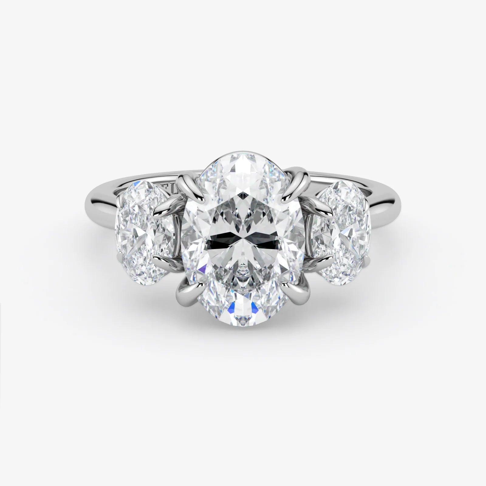 Diamond ring with a central oval-cut diamond and two smaller diamonds on a white background