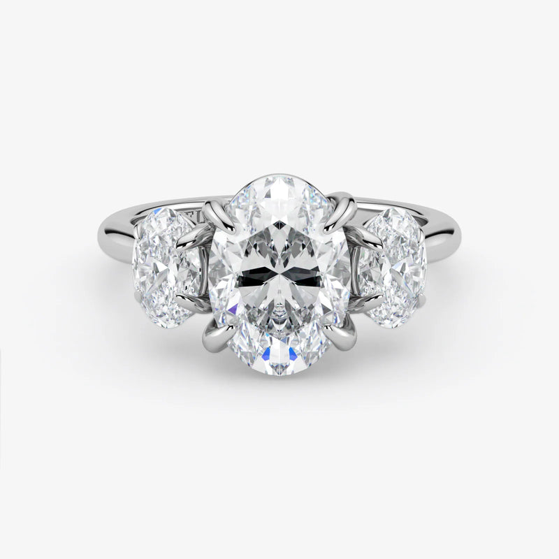 Diamond ring with a central oval-cut diamond and two smaller diamonds on a white background