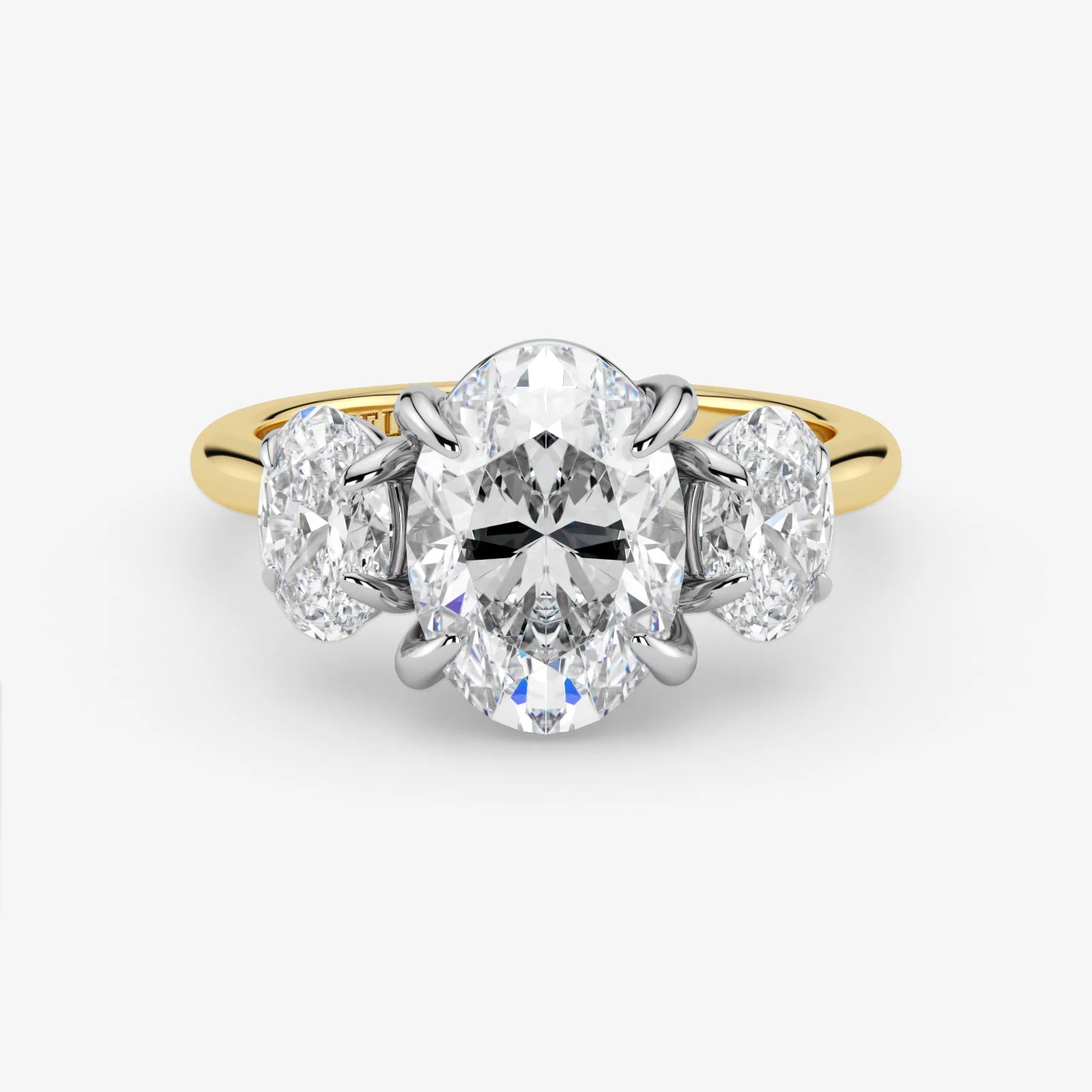 Diamond ring with a central oval-cut diamond flanked by two round-cut diamonds on a white background