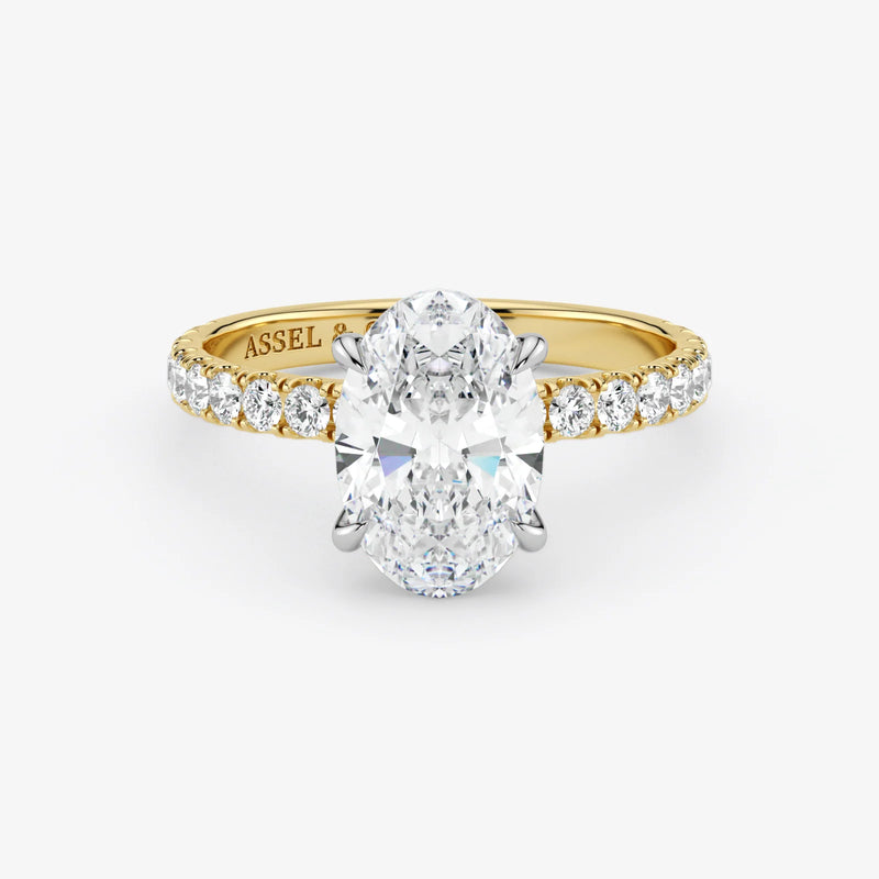 Gold ring with a large diamond and smaller diamonds on the band against a white background