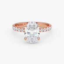 Rose gold ring with a large diamond and smaller diamonds on the band against a white background