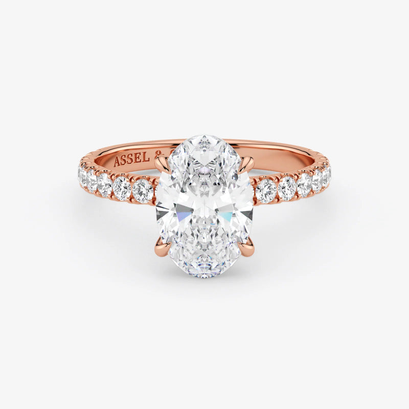 Rose gold ring with a large diamond and smaller diamonds on the band against a white background