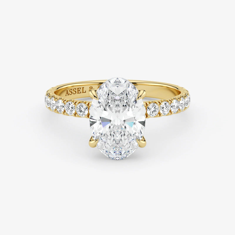 Gold ring with a large diamond and smaller diamonds on the band against a white background