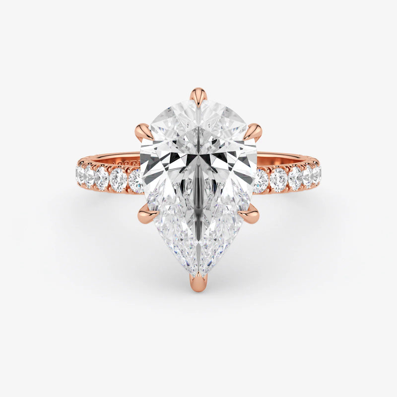 Rose gold ring with a large diamond and smaller diamonds on the band against a white background