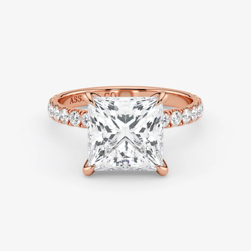 Rose gold ring with a large diamond and smaller diamonds on the band against a white background