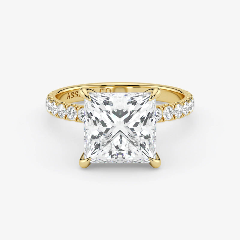 Gold ring with a large diamond and smaller diamonds on the band against a white background