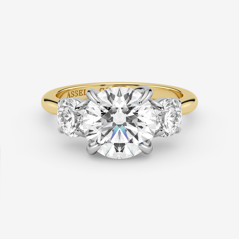 Gold ring with a large diamond and smaller diamonds on the sides against a white background