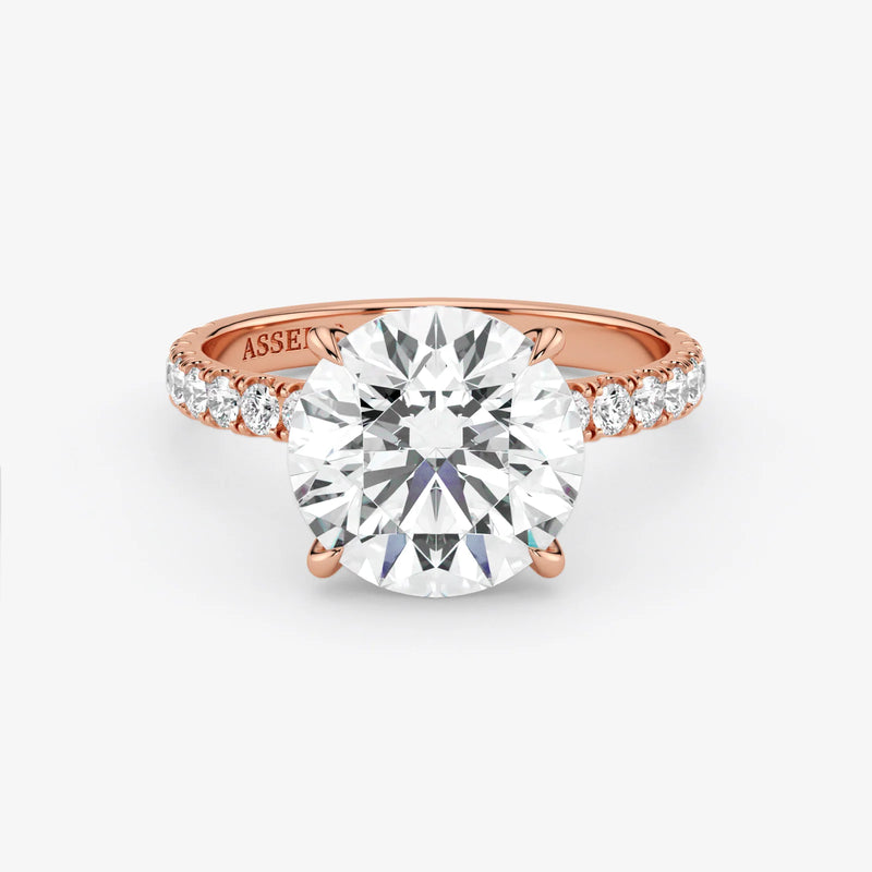 Rose gold ring with a large diamond and smaller diamonds on the band against a white background