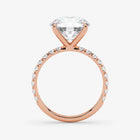 Rose gold ring with a large diamond and smaller diamonds on the band against a white background