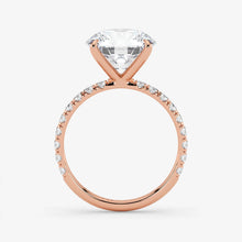 Rose gold ring with a large diamond and smaller diamonds on the band against a white background