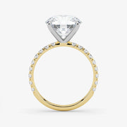 Gold ring with a large diamond and smaller diamonds on the band against a white background