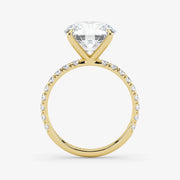 Gold ring with a large diamond and smaller diamonds on the band against a white background
