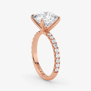 Rose gold ring with a large diamond and smaller diamonds on the band against a white background