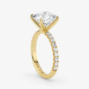 Gold ring with a large diamond and smaller diamonds on the band against a white background