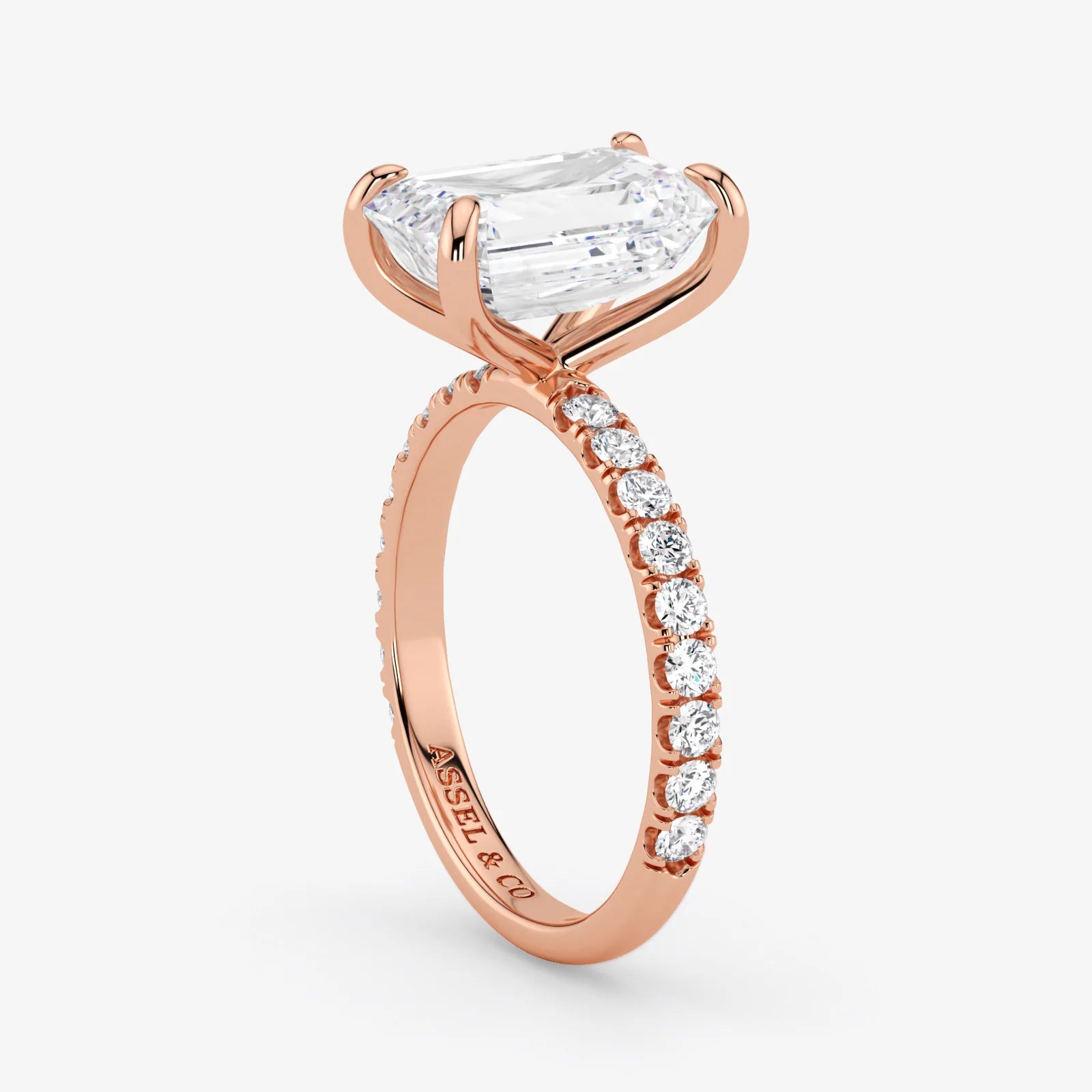 Rose gold ring with a large diamond and smaller diamonds on the band against a white background