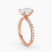 Rose gold ring with a large diamond and smaller diamonds on the band against a white background
