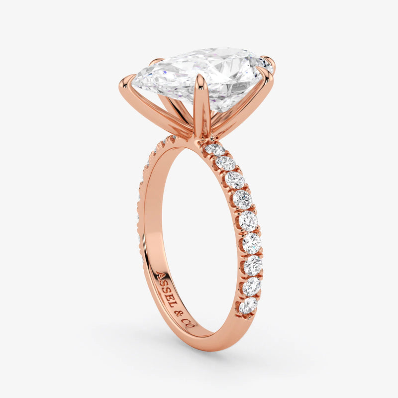 Rose gold ring with a large diamond and smaller diamonds on the band against a white background