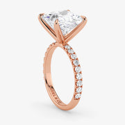 Rose gold ring with a large diamond and smaller diamonds on the band against a white background