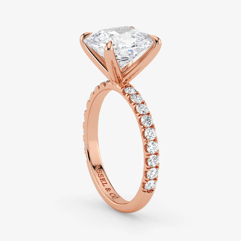 Rose gold ring with a large diamond and smaller diamonds on the band against a white background